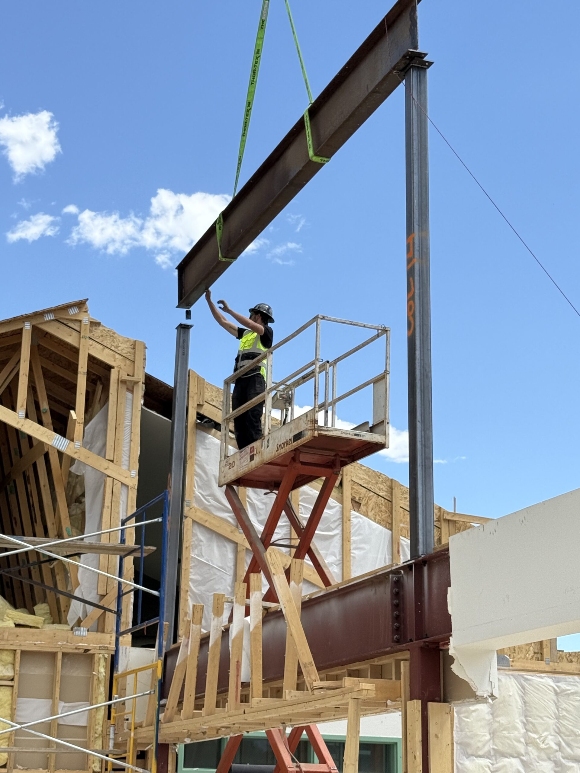 A steel beam is lowered onto steel supports within the library.