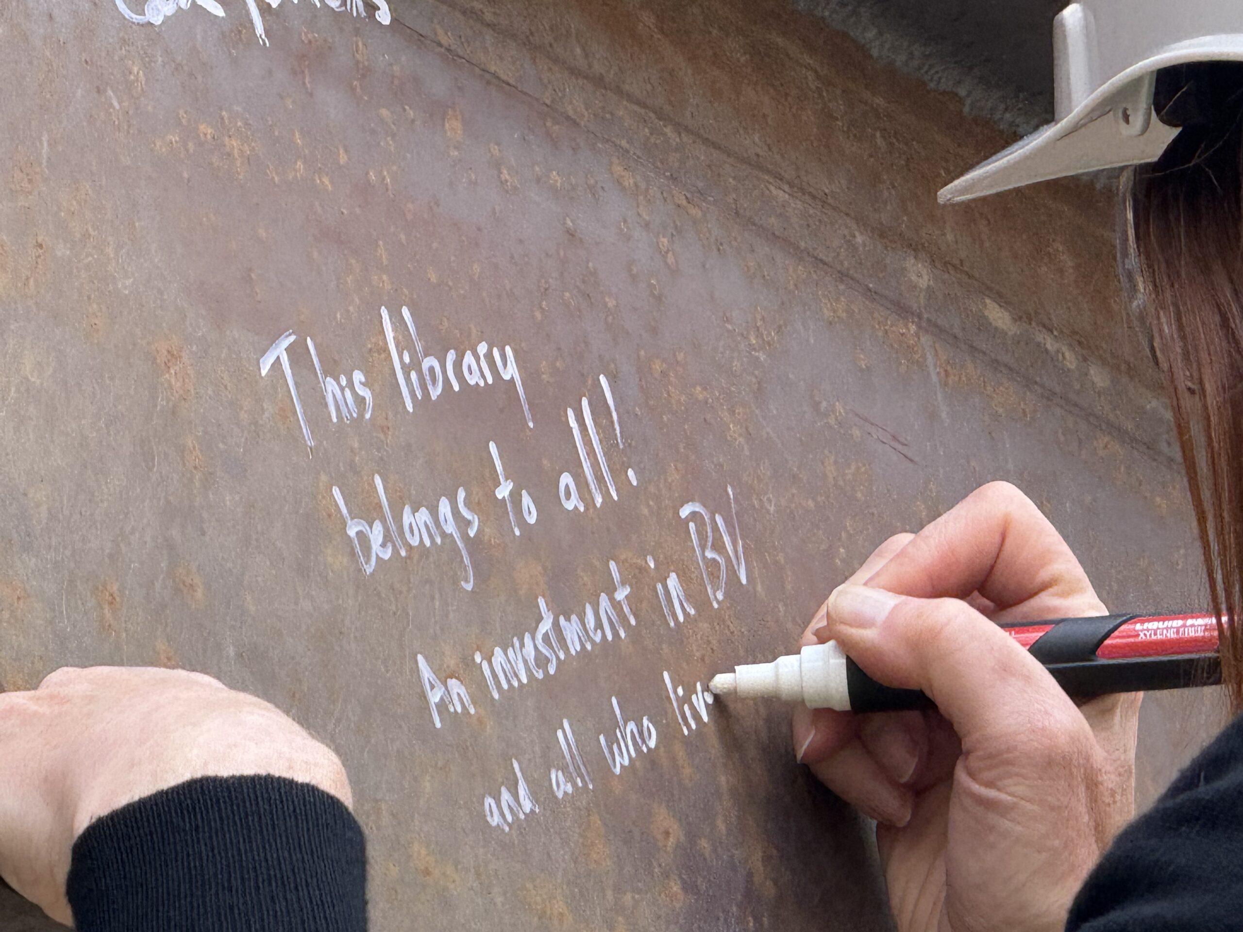 A message inscribed on a steel beam: This library belongs to all!