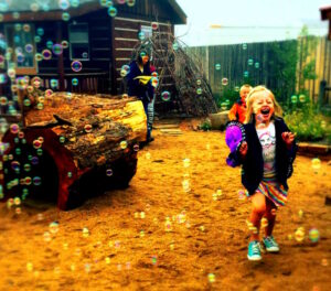Child playing with bubbles in the Red Feather Lakes Community Library playground
