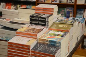 Stacks of new books on a table.