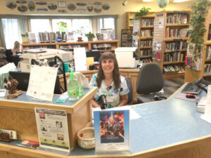 woman seated behind library circulation desk
